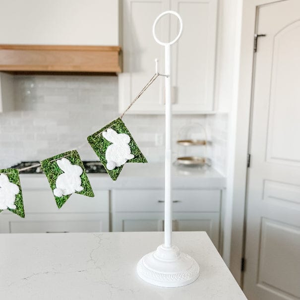 Tabletop garland stand on a buffet table holding a banner
